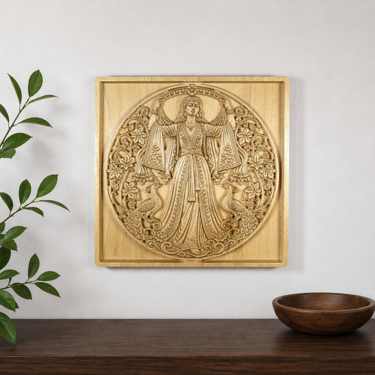 Anahita wood relief displayed on a wall above a shelf, showing how the Persian goddess carving looks in a modern interior.