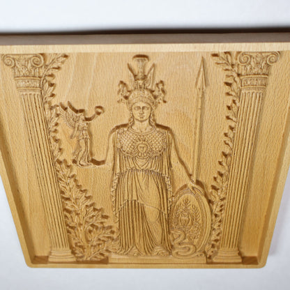 Detailed Athena wood carving showing the shield, helmet, spear, owl, olive details, Victory figure, and fine relief linework.
