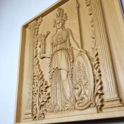 Side perspective of an Athena wood relief showing the raised goddess carving, recessed frame, botanical details, and dimensional woodwork.