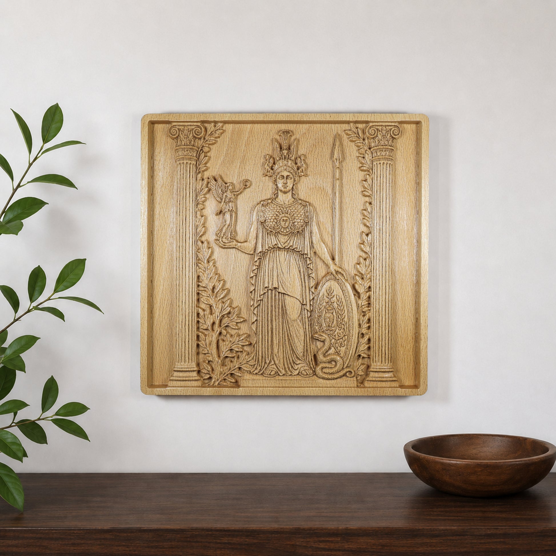 Athena wood relief displayed on a wall above a shelf, showing how the Greek mythology carving looks in a modern interior.