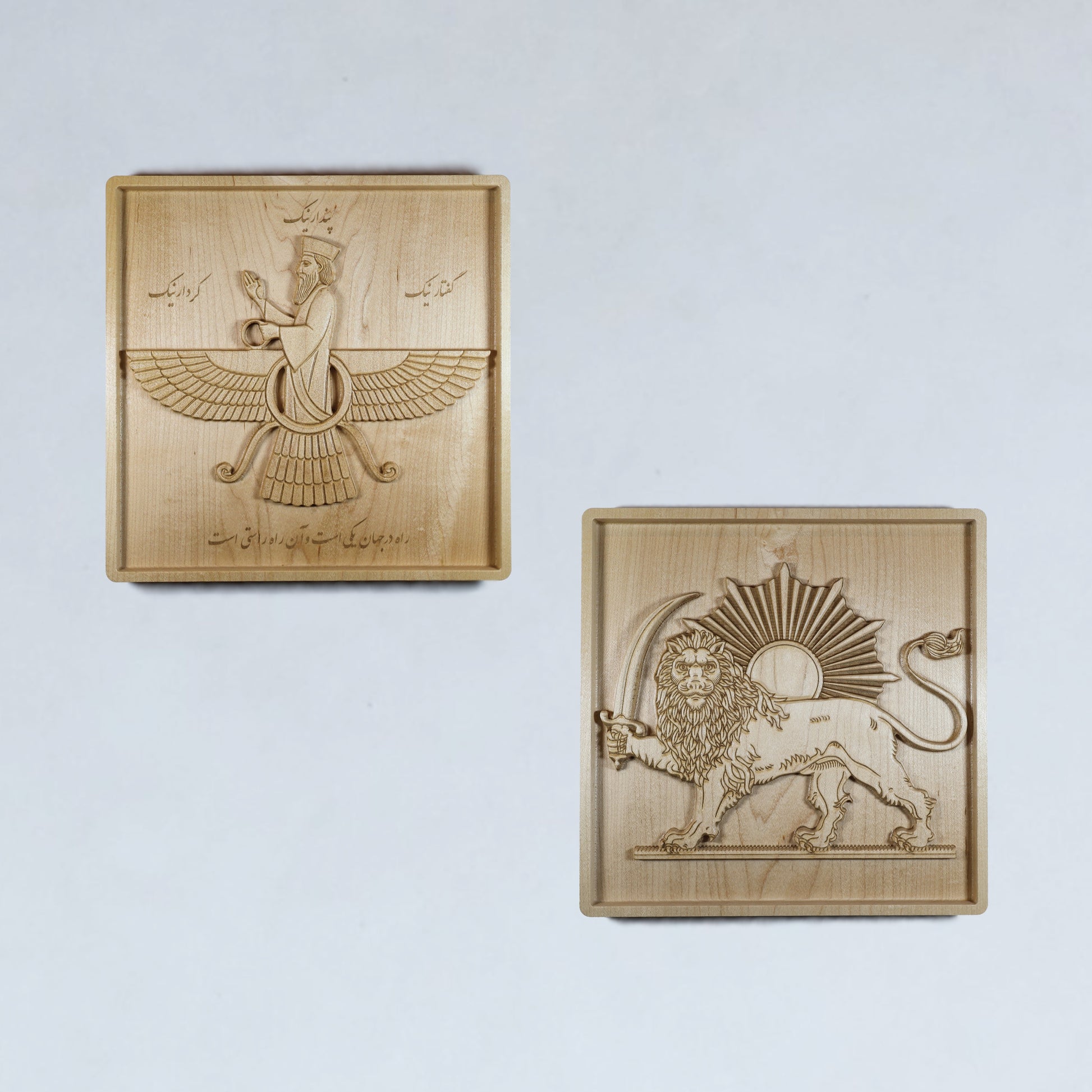 Set of two 11 inch Persian wood reliefs featuring the Faravahar and Lion and Sun symbols, carved in solid hard maple with matching frames.