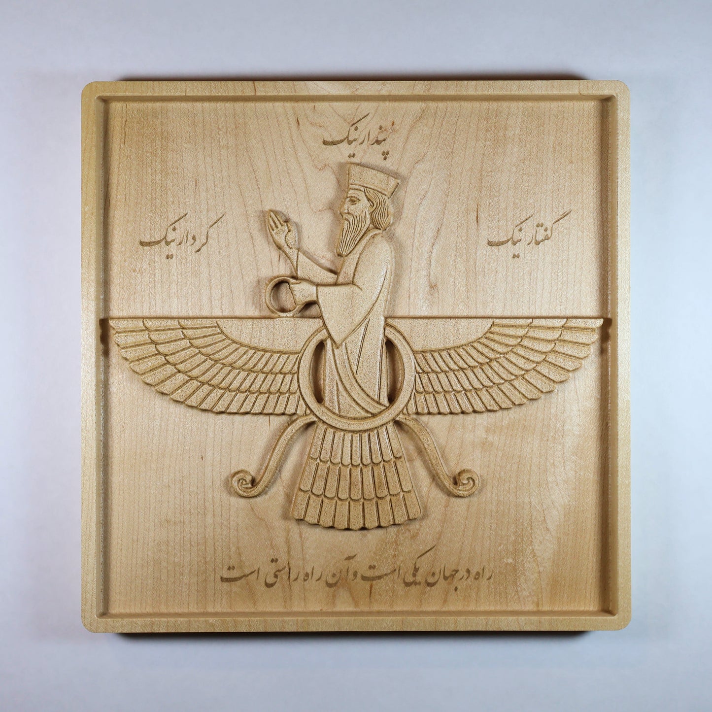 Front view of the large Faravahar wood relief showing the winged Persian symbol, Farsi inscriptions, feather details, and natural hard maple.