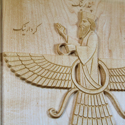 Close-up of the Faravahar carving showing the central figure, layered wings, ribbons, Farsi inscription, and fine maple wood grain.