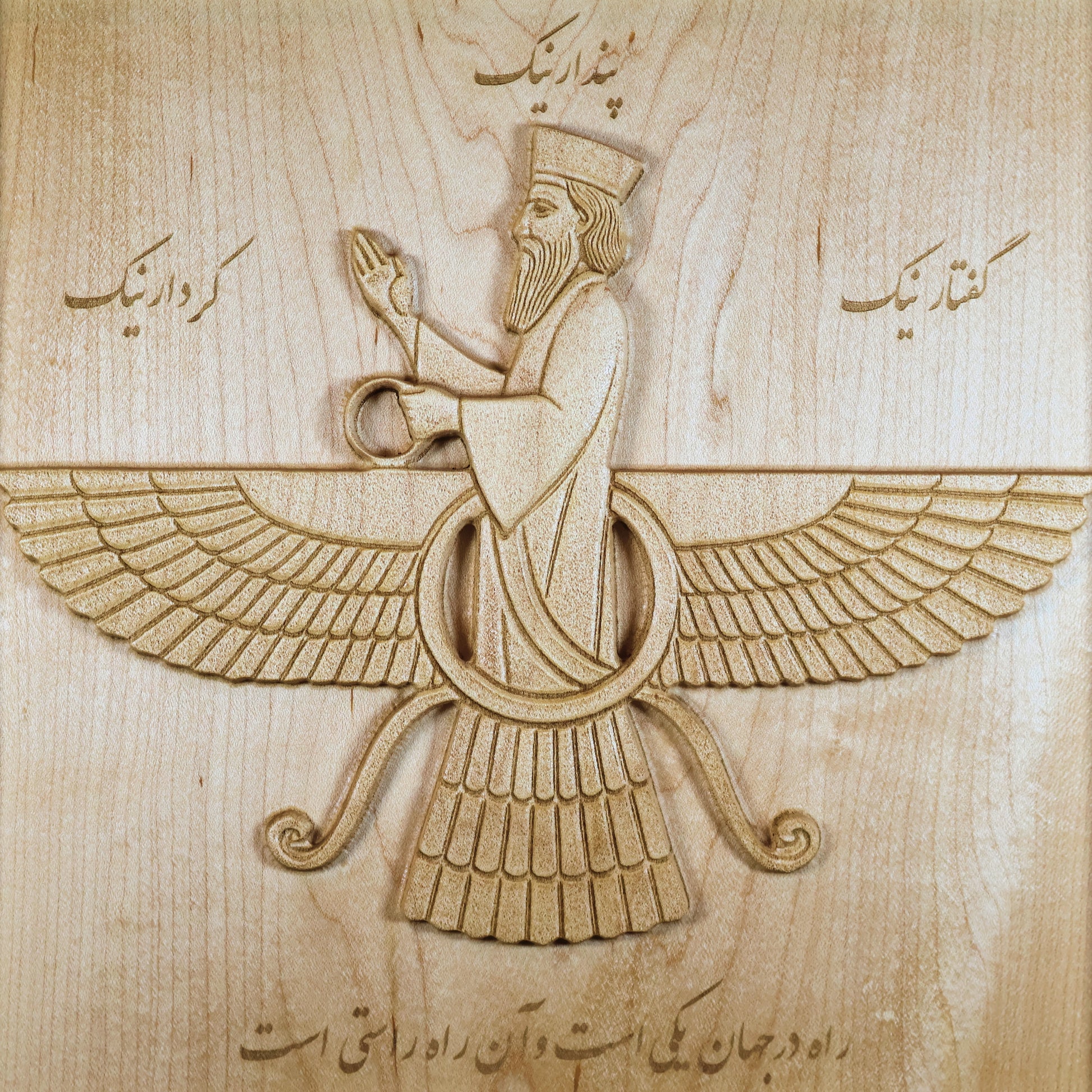 Close-up front detail of 11 inch Faravahar wood wall art carved in solid hard maple, showing raised wings, central figure, laser-engraved Farsi calligraphy, smooth maple grain, detailed carving lines, and Persian carved wood relief texture.
