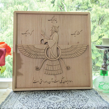 11 inch Faravahar wood relief displayed upright in a bright interior, showing its scale, Persian symbolism, and natural maple tone.