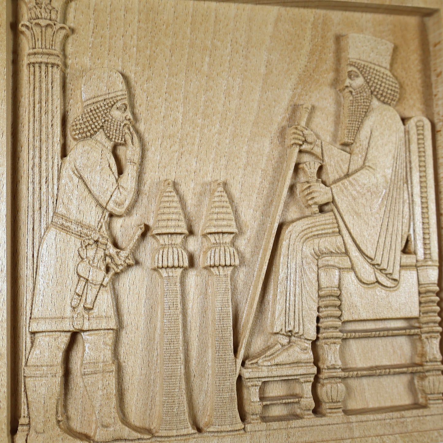 Close detail of the Persepolis Royal Audience wood relief showing King Darius, an attendant, palace stands, throne carving, column detail, and natural beech wood finish.