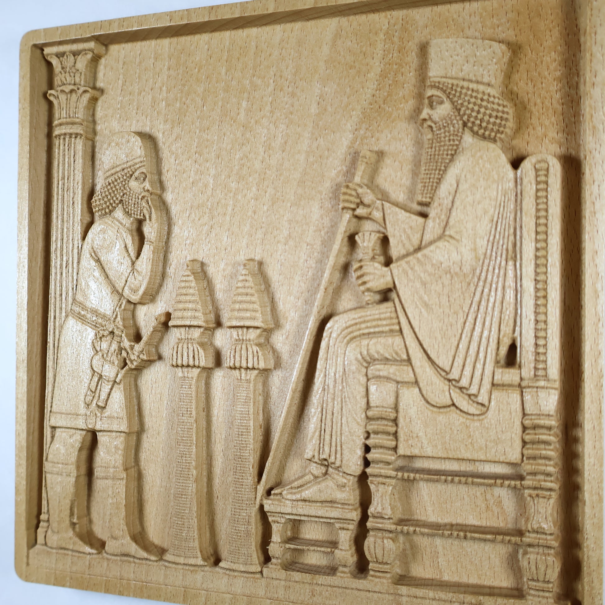 Side display view of the Persepolis Royal Audience wood relief showing the seated king, attendant figure, palace column, ceremonial objects, raised carving depth, and natural beech wood finish.