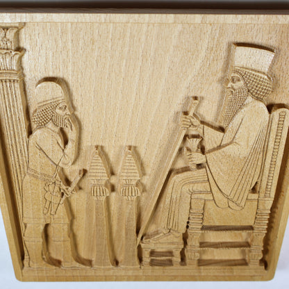 Overhead angled view of the Persepolis Royal Audience wood relief showing the seated king, approaching figure, ceremonial stands, throne, column edge, and natural beech wood finish.