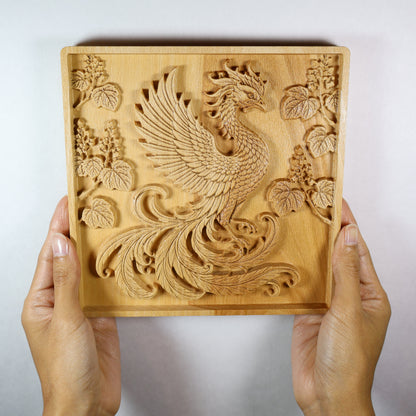 Japanese Phoenix wood relief held in hands, showing the size, carved Hoo bird, paulownia details, and natural wood finish.