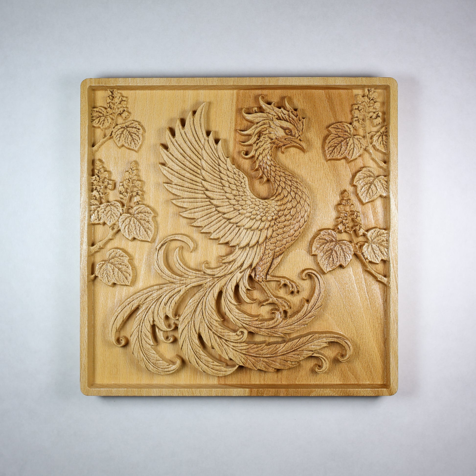 Front view of a Japanese Phoenix wood relief showing the Hoo bird, paulownia branches, carved feathers, square frame, and natural wood finish.