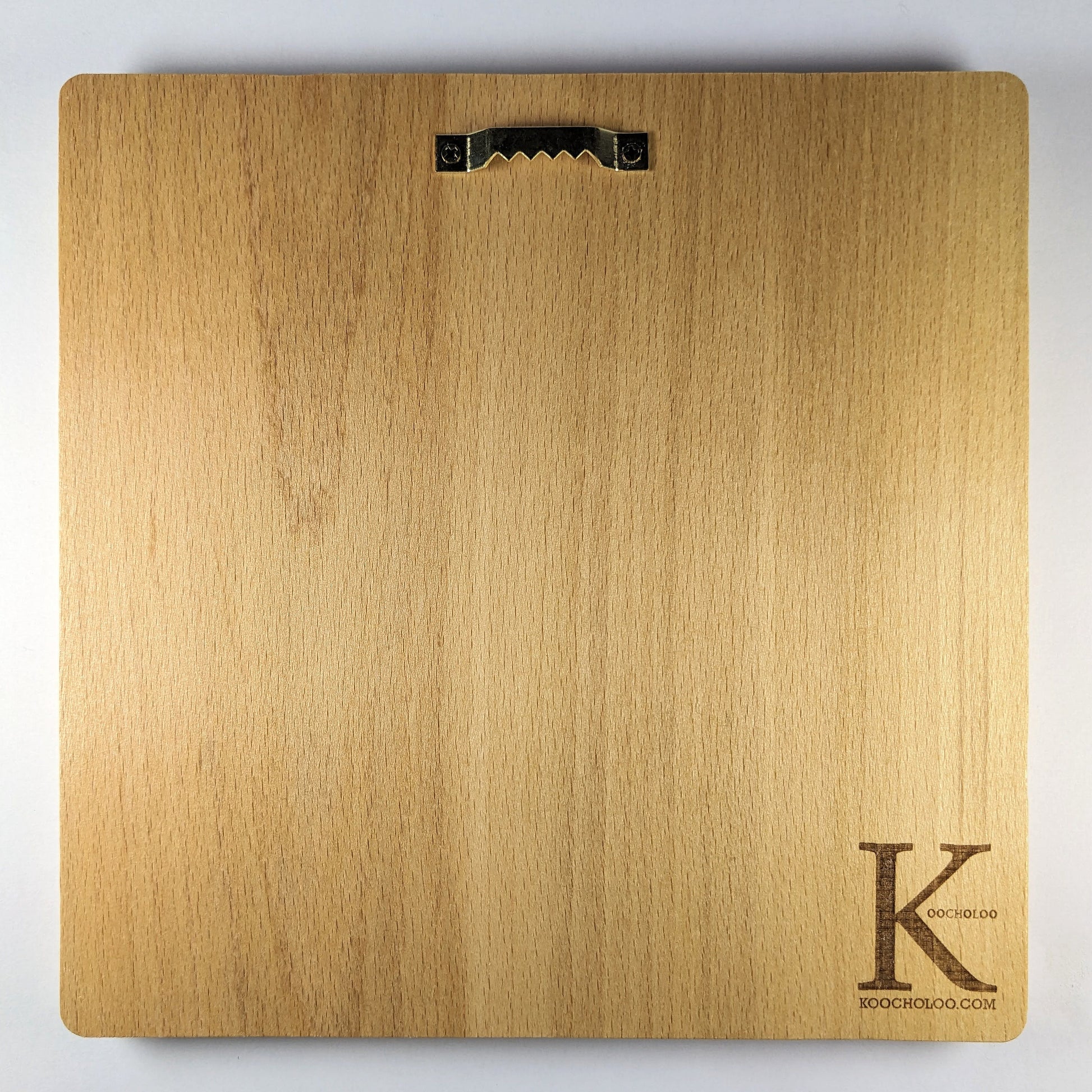 Back view of the Komainu wood relief with natural wood grain, rounded corners, metal wall hanger, and engraved Koocholoo logo with Koocholoo.com.