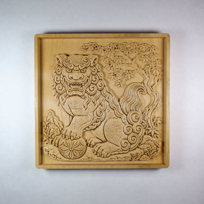 Front view of a Japanese Komainu guardian lion dog wood relief with a carved floral ball, curled mane, tree details, square frame, and natural wood finish.