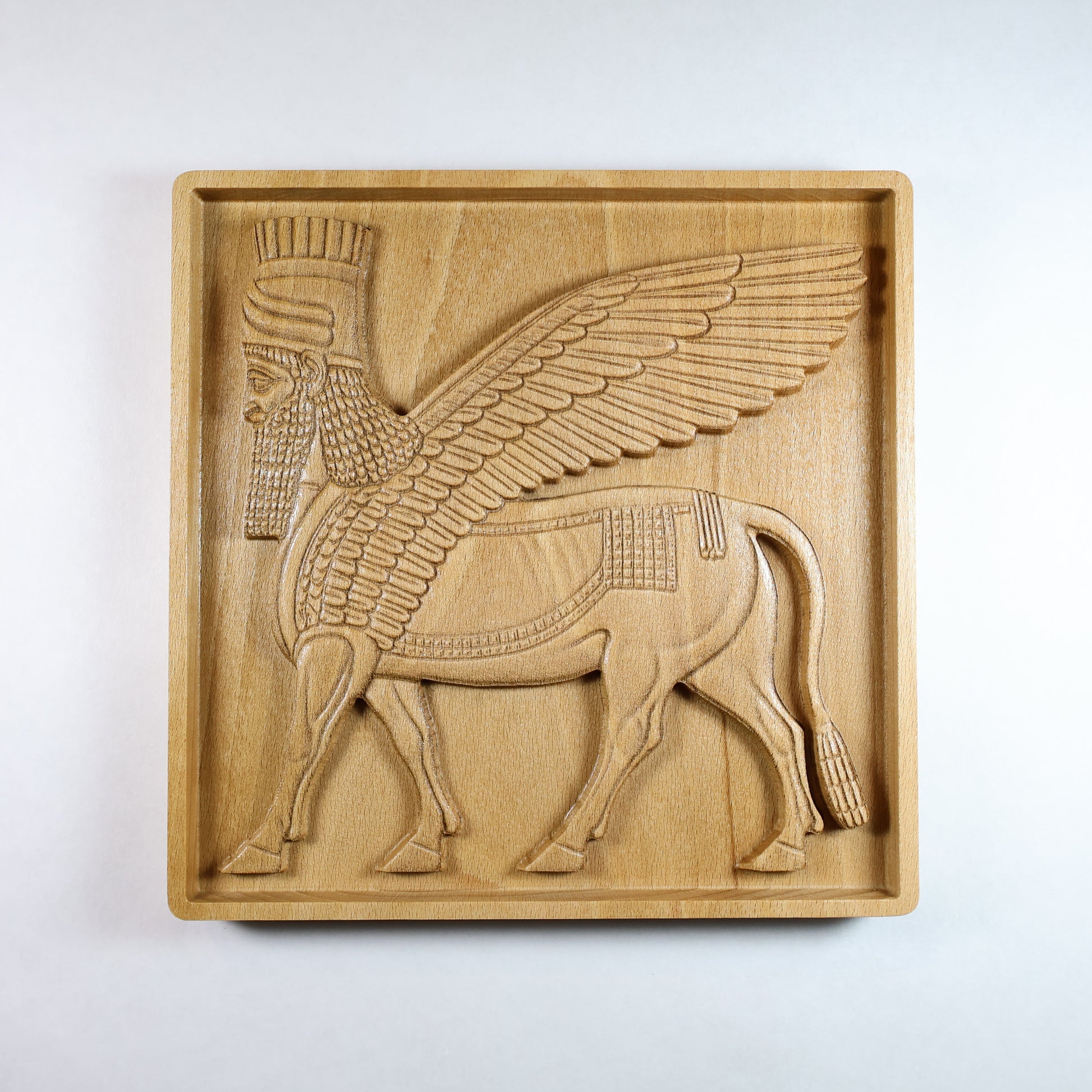 Front view of Lamassu Assyrian guardian carved wood relief, winged bull with human head, CNC-carved solid beech wood, 3D bas relief wall art, ancient Mesopotamian home decor.