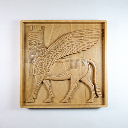 Front view of Lamassu Assyrian guardian carved wood relief, winged bull with human head, CNC-carved solid beech wood, 3D bas relief wall art, ancient Mesopotamian home decor.