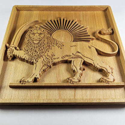 Low-angle close-up of Lion and Sun wood wall art carved in solid beech, showing raised 3D relief depth, standing lion with sword, curved tail, sunburst rays, framed panel, detailed lion face, and warm wood grain.