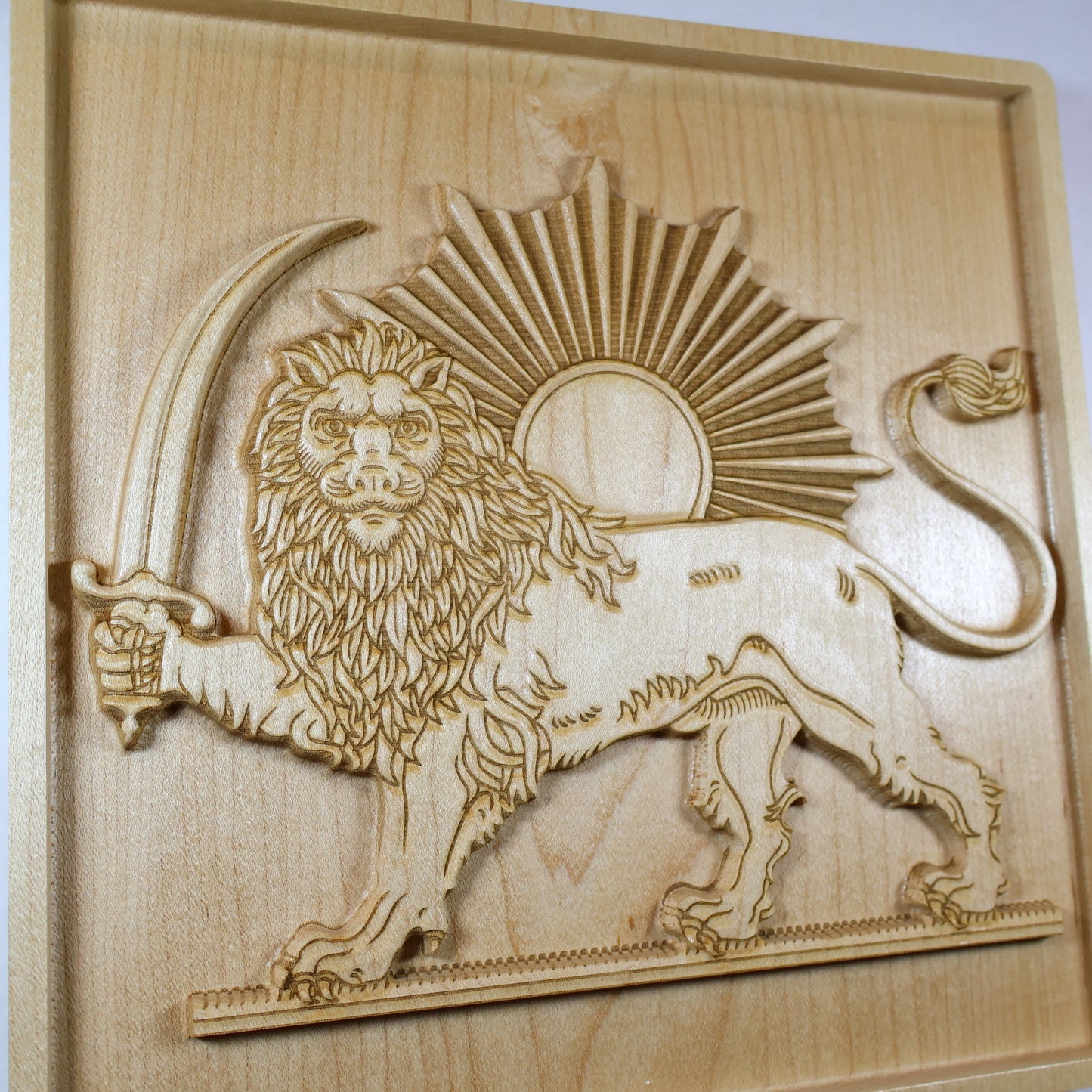 Three-quarter view of the Lion and Sun wood carving showing the crowned lion, sword, sun rays, raised details, and warm maple finish.