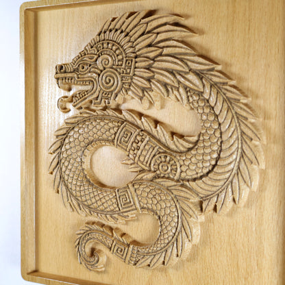 Flat right view of Quetzalcoatl 7x7 inch beech wood relief against white background, full coiled feathered serpent with spiral head ornament, curved tail, recessed border frame, and warm natural wood finish