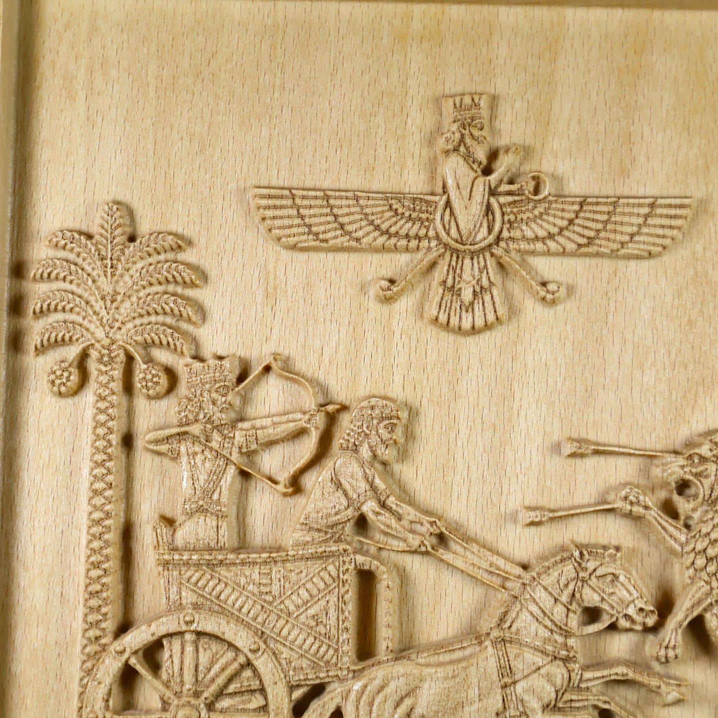 Close front view of the Royal Seal of Darius carving with the chariot hunt, royal figures, palm trees, winged emblem, and natural wood texture.