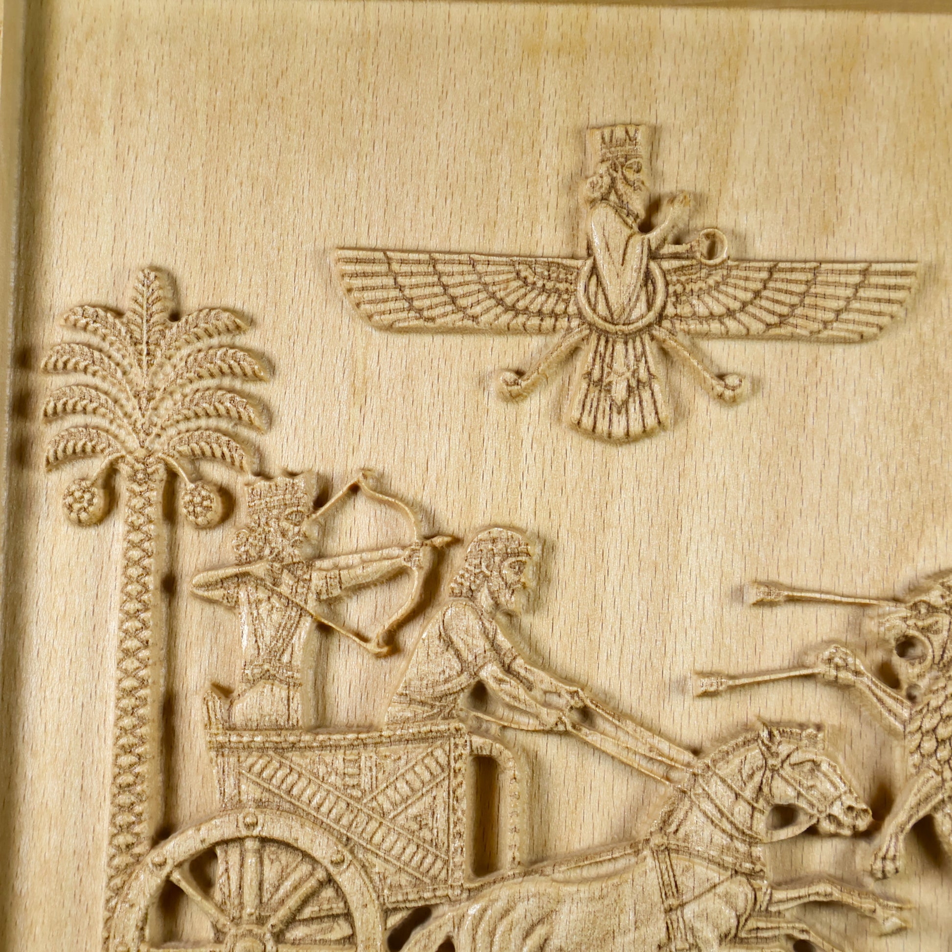 Close front view of the Royal Seal of Darius carving with the chariot hunt, royal figures, palm trees, winged emblem, and natural wood texture.