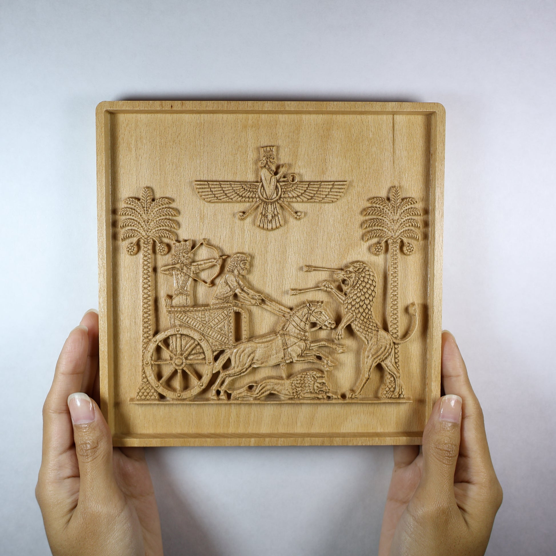 Royal Seal of Darius relief held in hands, showing the size, square frame, chariot scene, horses, lions, and natural wood tone.