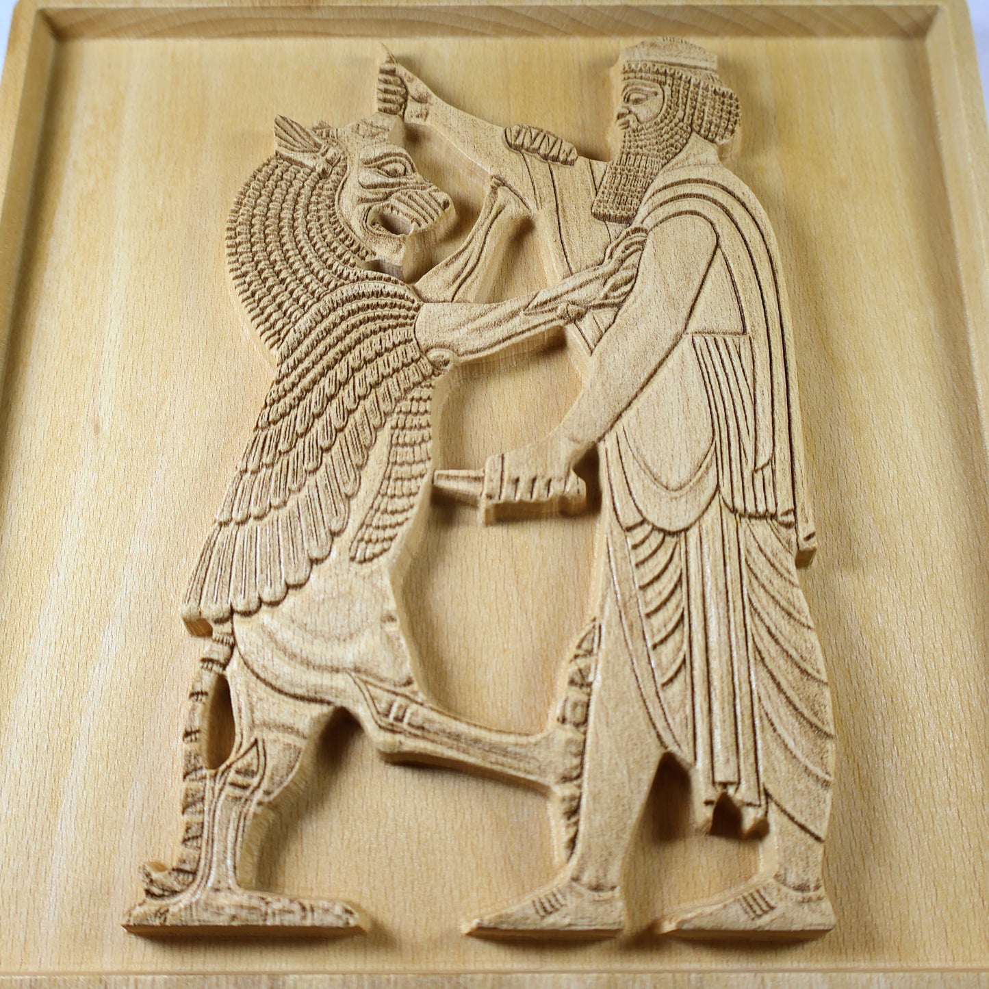 Close front detail of Shahriar and the Lion wood relief showing the raised lion, Persian figure, carved robe, short blade, beard texture, and natural beech wood finish.