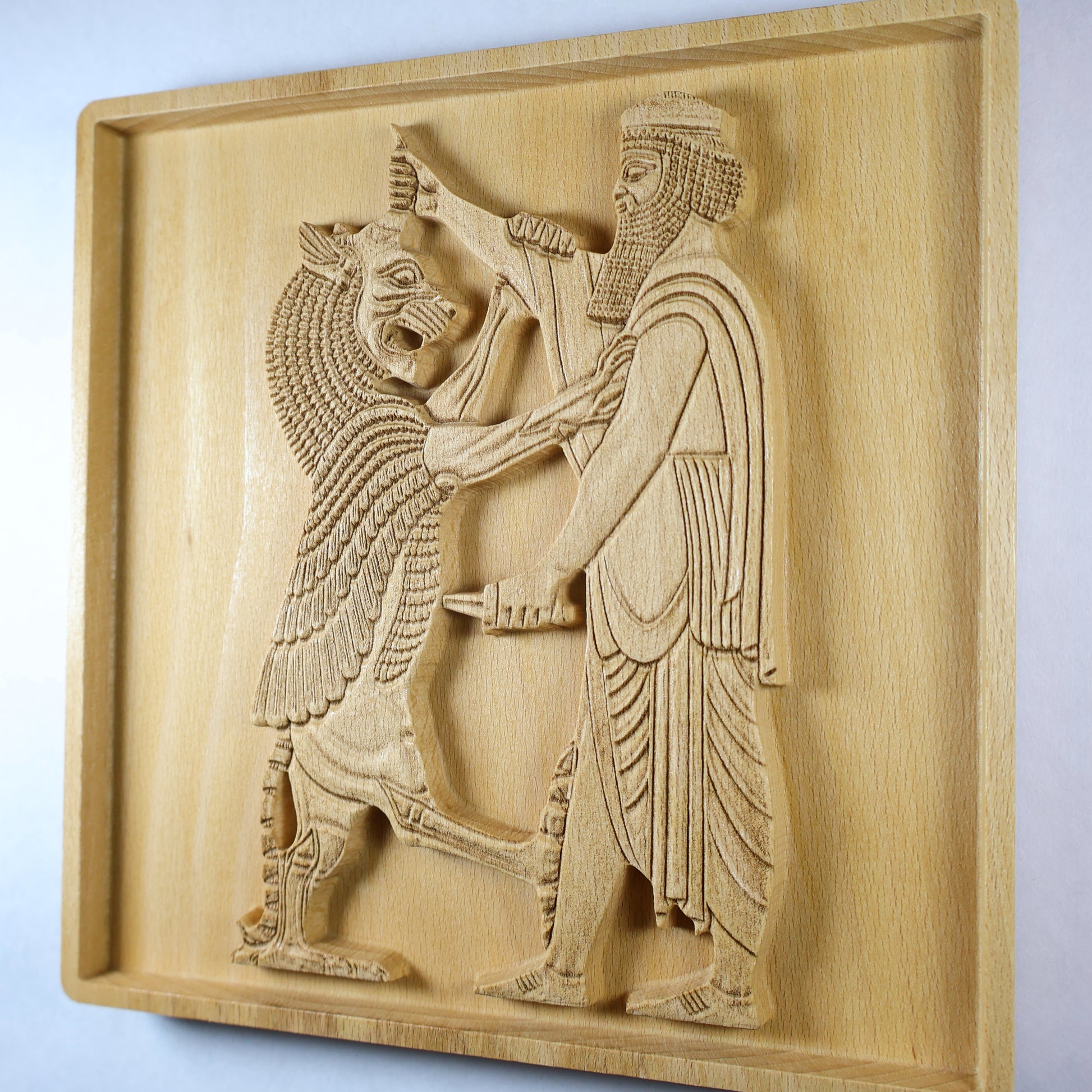 Right-side angle of Shahriar and the Lion wood relief showing the raised Persian figure and lion scene, carved blade, robe details, recessed frame, and natural beech wood finish.