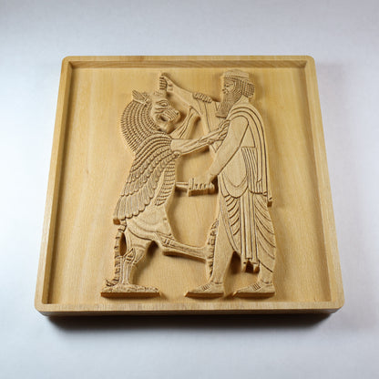 Three-quarter view of the Shahriar and the Lion wood relief showing the Persian figure, raised lion, carved weapon, robe folds, recessed frame, and natural beech wood finish.