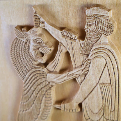 Macro close-up of Shahriar and the Lion wood relief showing the lion’s open mouth, raised arm, carved beard, robe folds, dagger handle, and natural wood relief depth.