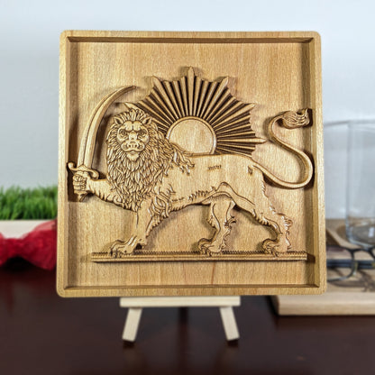 Lion and Sun wood wall art displayed on a small easel, featuring a Persian carved wood relief with standing lion, raised sword, curved tail, sunburst rays, framed beech panel, and tabletop display for office, shelf, or home.