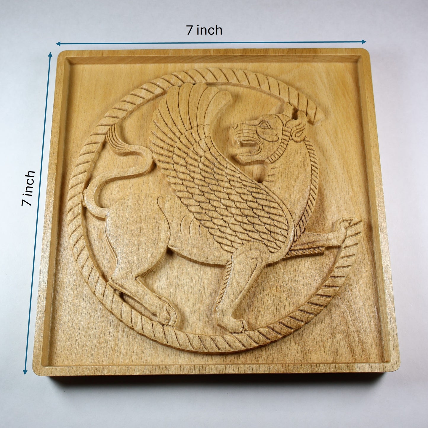 Achaemenid Winged Lion Roundel with 7 inch width and height markers, showing the carved Persian griffin, circular border, and natural wood finish.