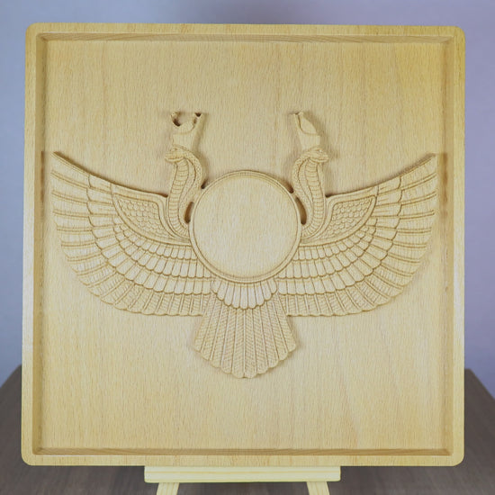 Rotating tabletop video of an Egyptian Winged Sun Disk wood relief, showing the front and angled side views of the carved Ra-Horus sun symbol, wide feathered wings, twin uraeus cobras, raised bas relief depth, and natural beech wood finish.