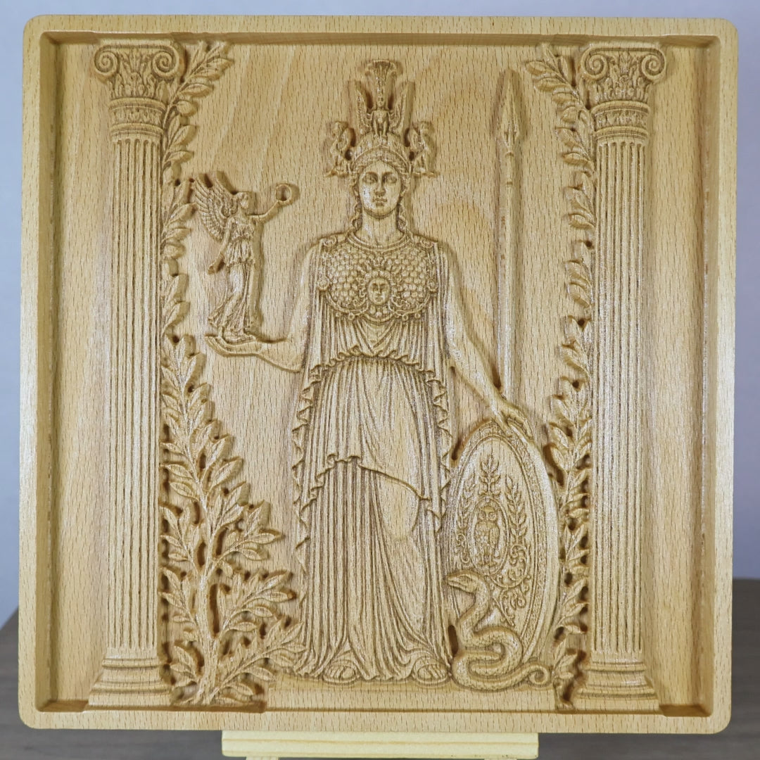 Rotating tabletop video of the Athena wood relief, showing front and angled side views of the Greek goddess, carved shield, spear, owl, olive branches, classical details, raised relief depth, and natural beech wood finish.