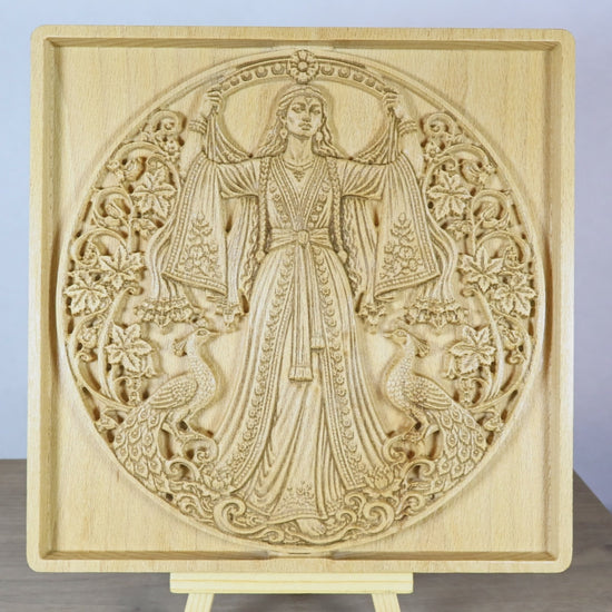 Rotating tabletop video of the Anahita wood relief, showing front and angled side views of the Persian goddess, flowing dress, peacocks, floral carving, raised relief depth, and natural beech wood finish.