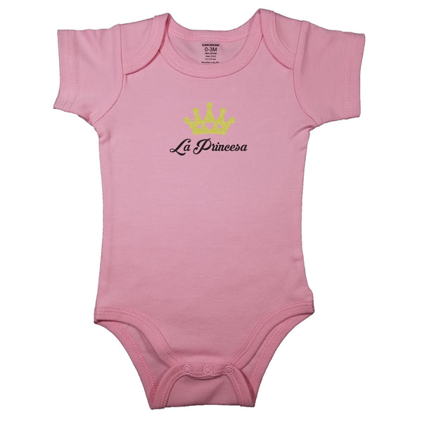 Spanish baby bodysuit with golden princess crown. Pink baby girl clothes with the words "La Princesa". Pink short sleeve baby bodysuit with the words "The Princess" in Spanish.